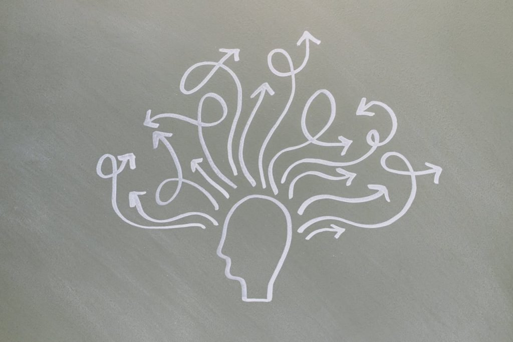 Conceptual chalk drawing illustrating mental health challenges with arrows representing thoughts.